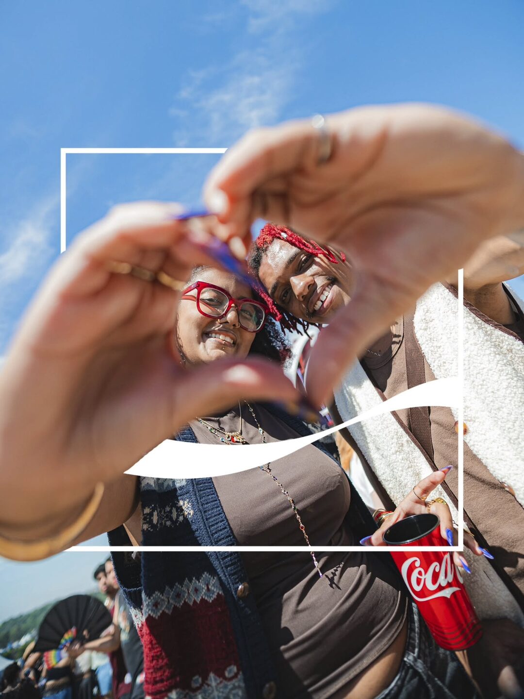 mãos emoldurando um copo de coca-cola